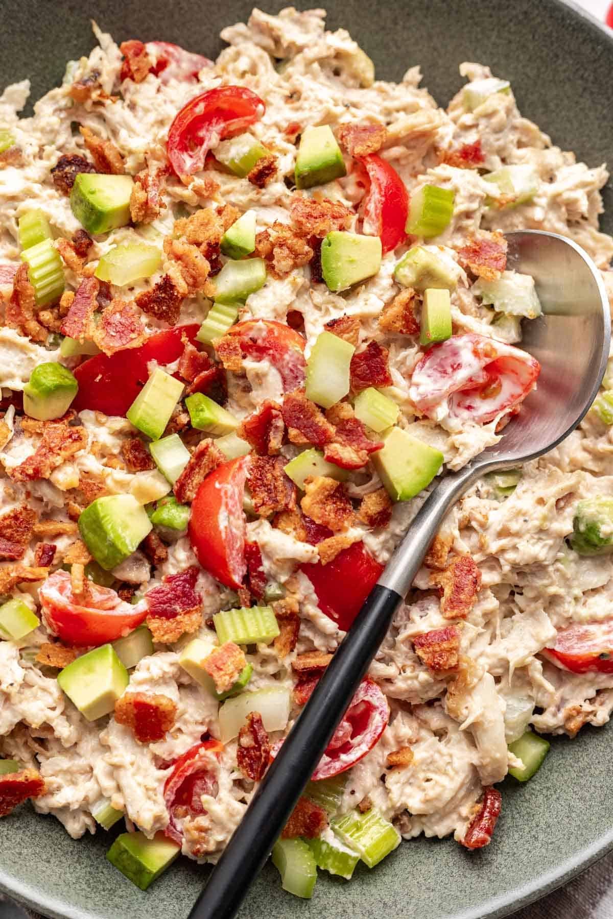 Avocado BLT chicken salad in a green bowl.