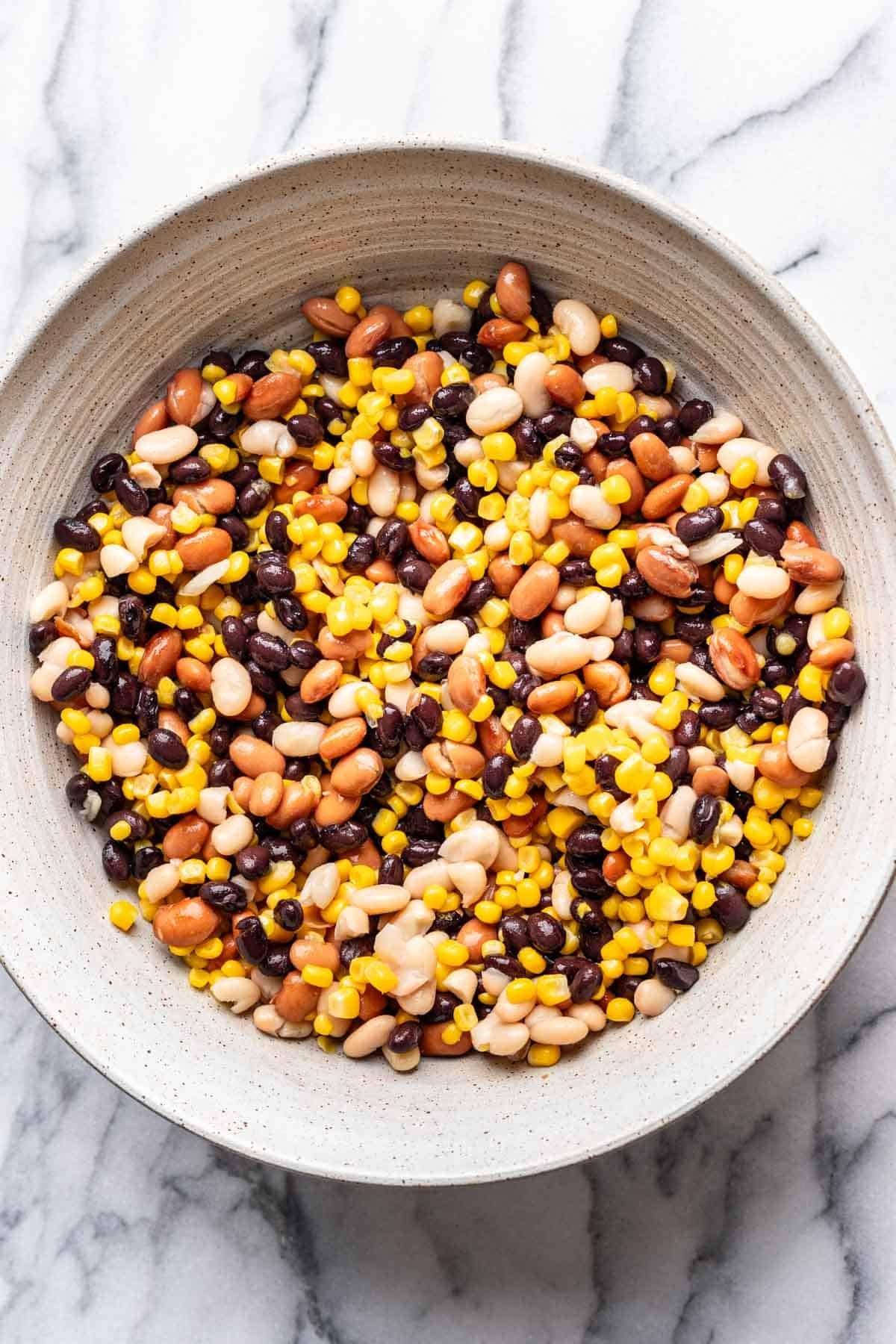 Rinsed beans and corn mixed together in a mixing bowl.
