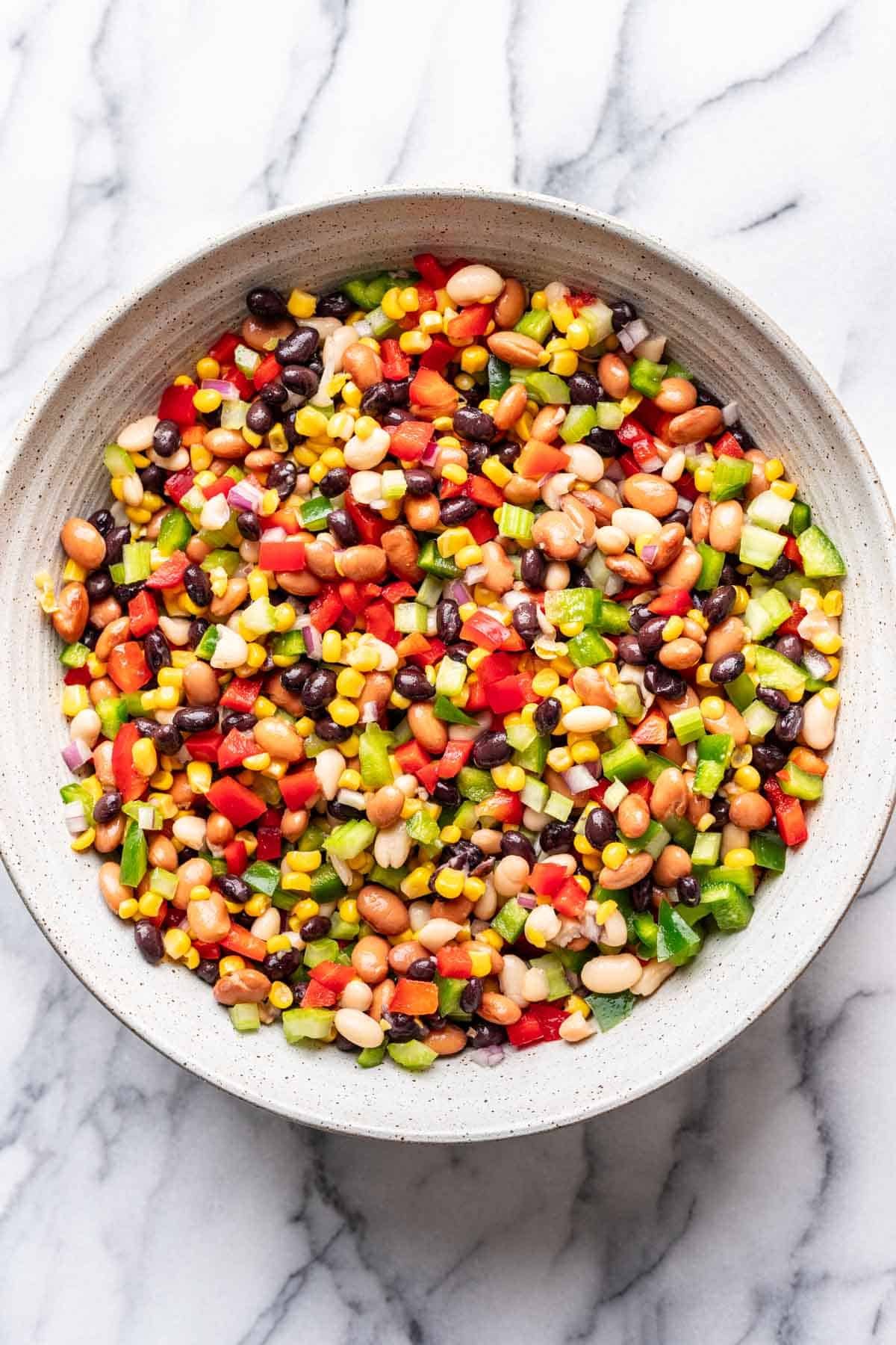 Veggies added to the beans and corn in the mixing bowl.