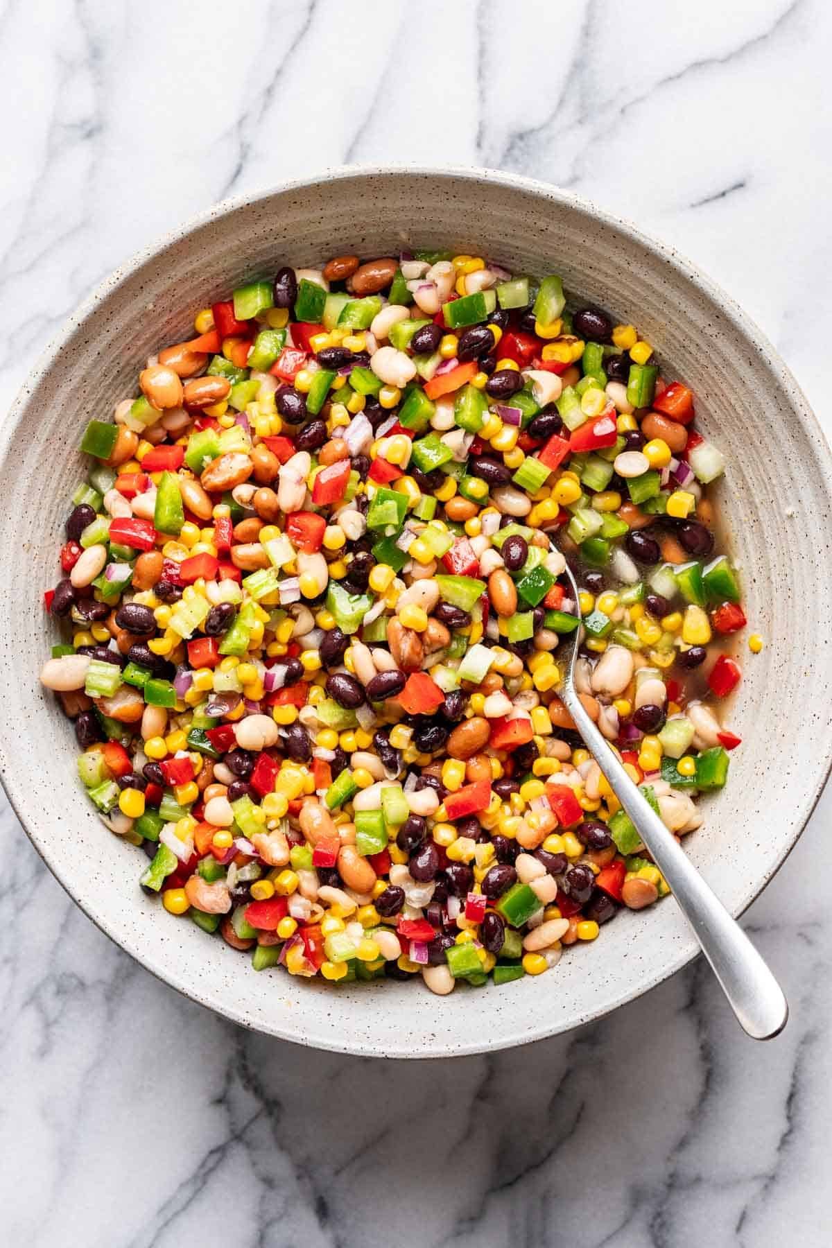 Dressing added to the bowl with the beans, corn, and veggies.