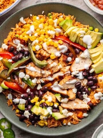 Chicken fajita bowl with all the toppings in a green bowl.