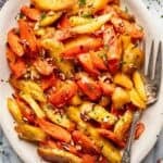 Maple roasted carrots and parsnips on a white serving platter.