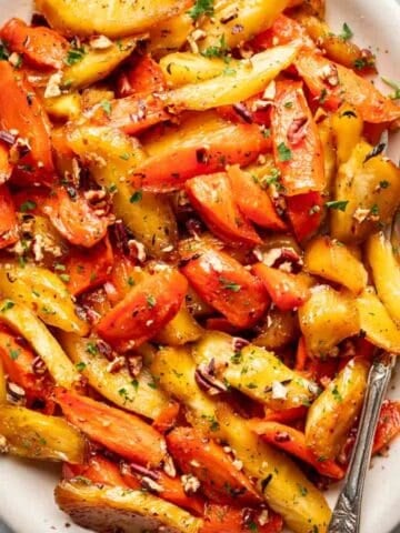 Maple roasted carrots and parsnips on a white serving platter.