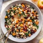 Pumpkin couscous salad in a large serving bowl with serving tongs.
