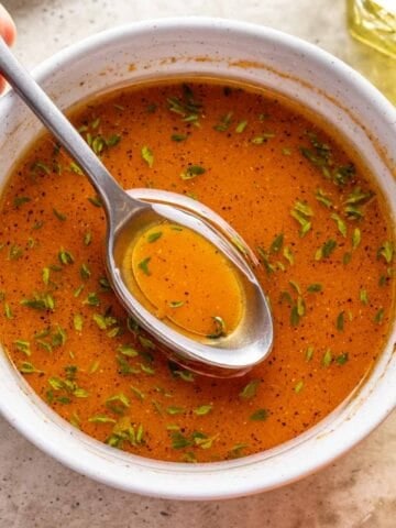 Fall pumpkin salad dressing in a white bowl with a serving spoon.