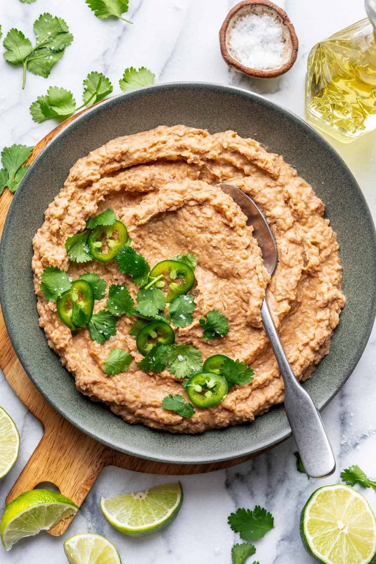 Homemade refried beans in a green bowl.