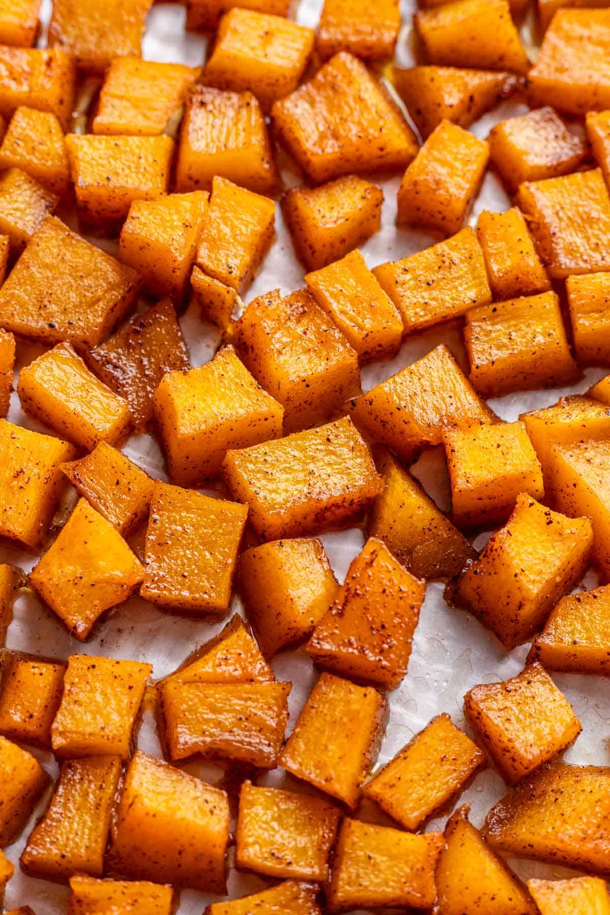 Maple brown sugar roasted pumpkin with caramelized edges on a baking sheet.