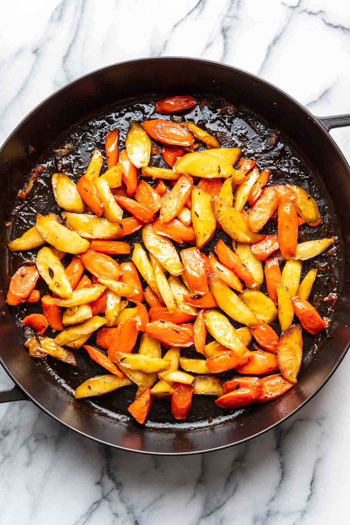 Roasted carrots and parsnips in a large roasting pan.