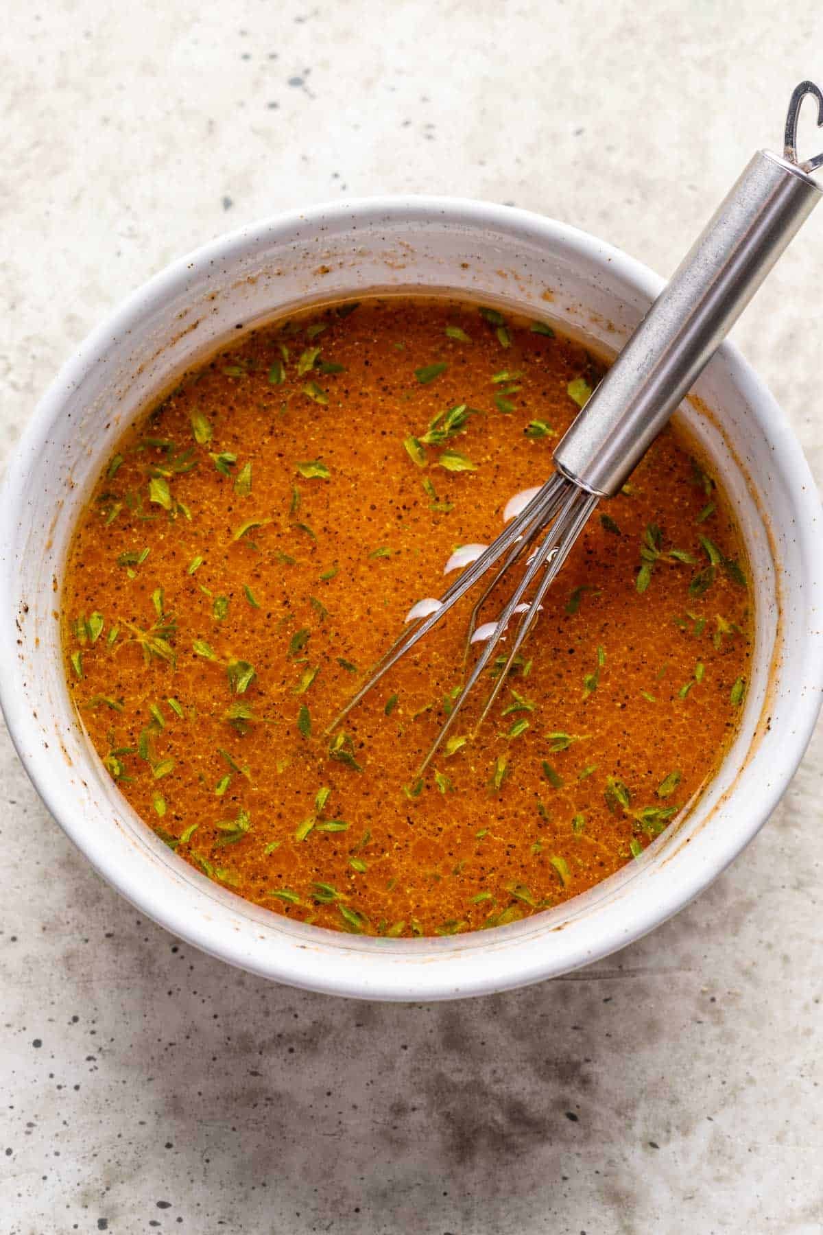 Pumpkin salad dressing ingredients whisked together in a bowl.