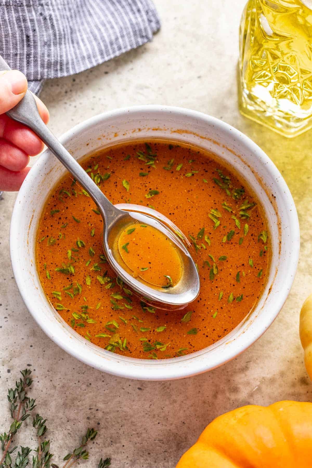 A spoon scooping out some pumpkin salad dressing from a bowl.