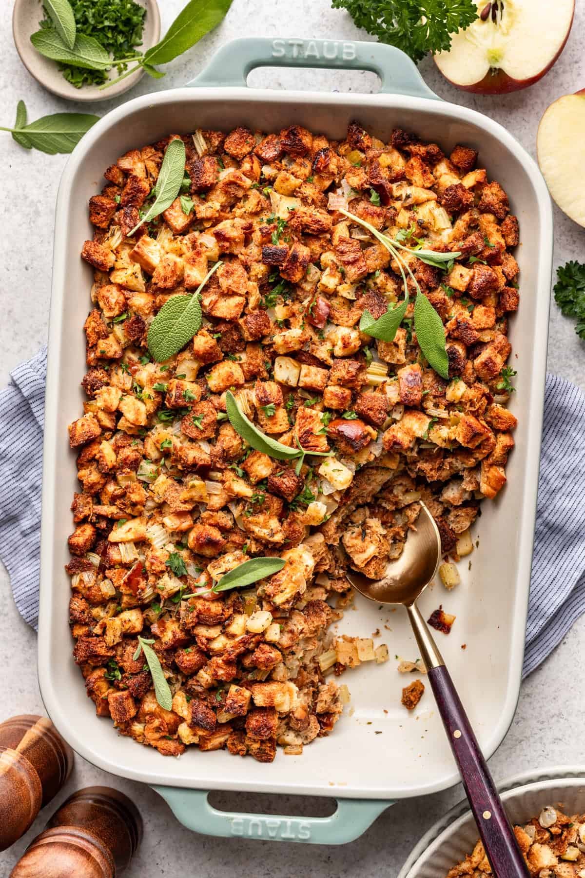 Challah stuffing in a baking dish with a serving spoon.