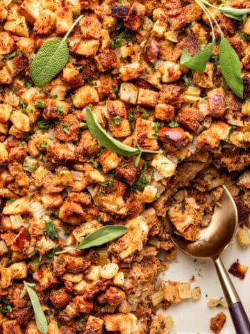 Challah stuffing in a baking dish with a serving spoon.