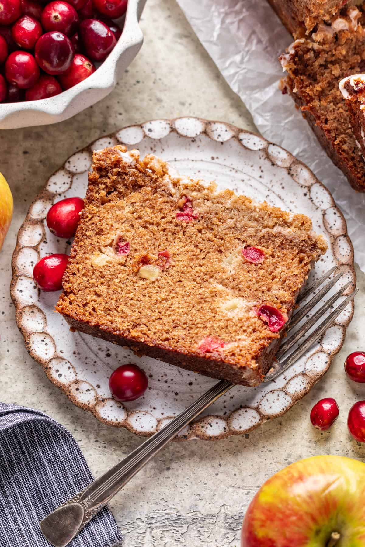 A slice of cranberry apple bread on a plate.