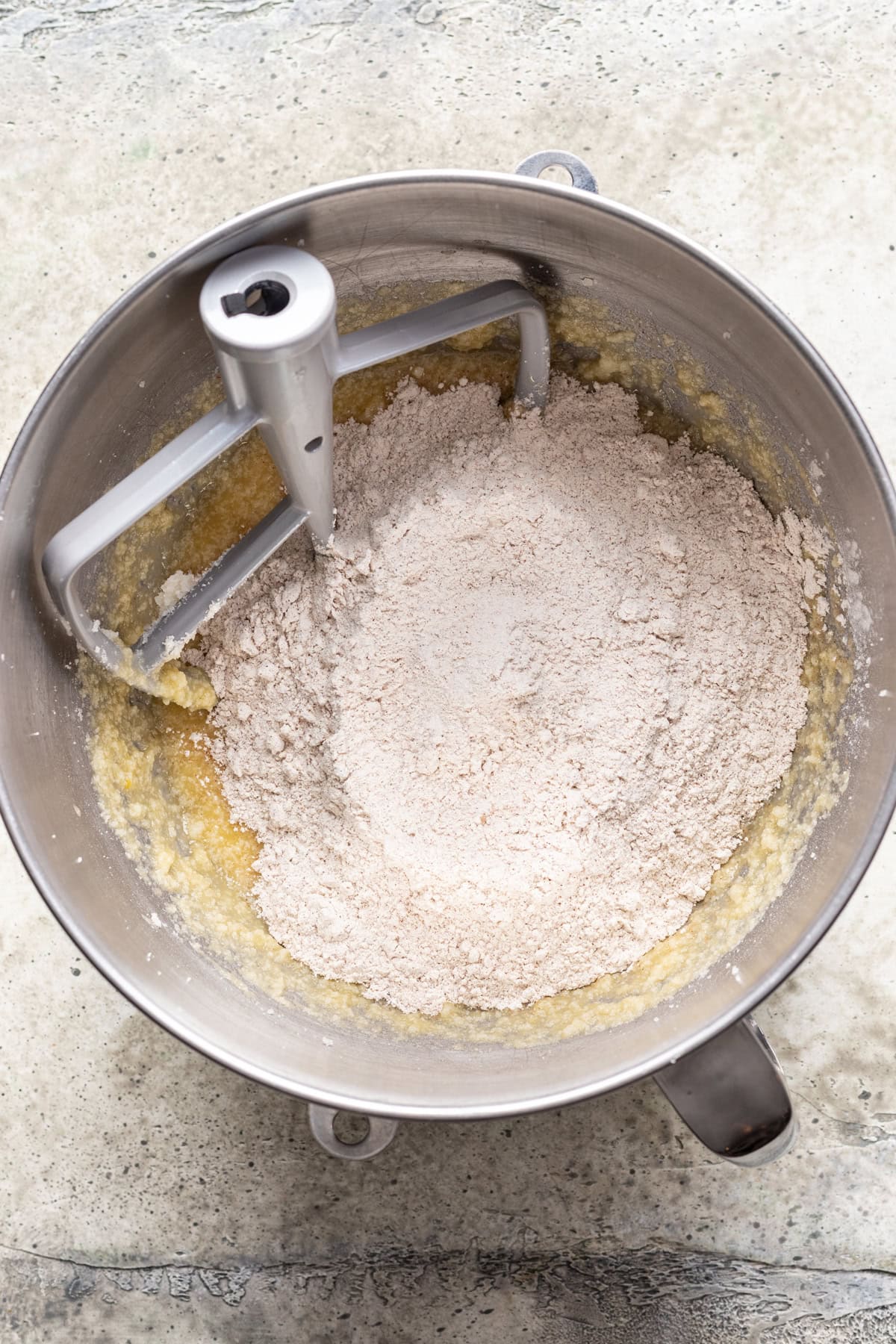 Flour mixture added to the wet ingredients in a mixing bowl.