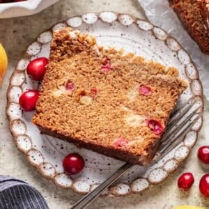 A slice of cranberry apple bread on a plate.
