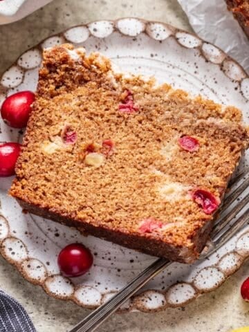 A slice of cranberry apple bread on a plate.
