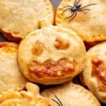 Jack o Lantern Pizza Rolls stacked on a plate.