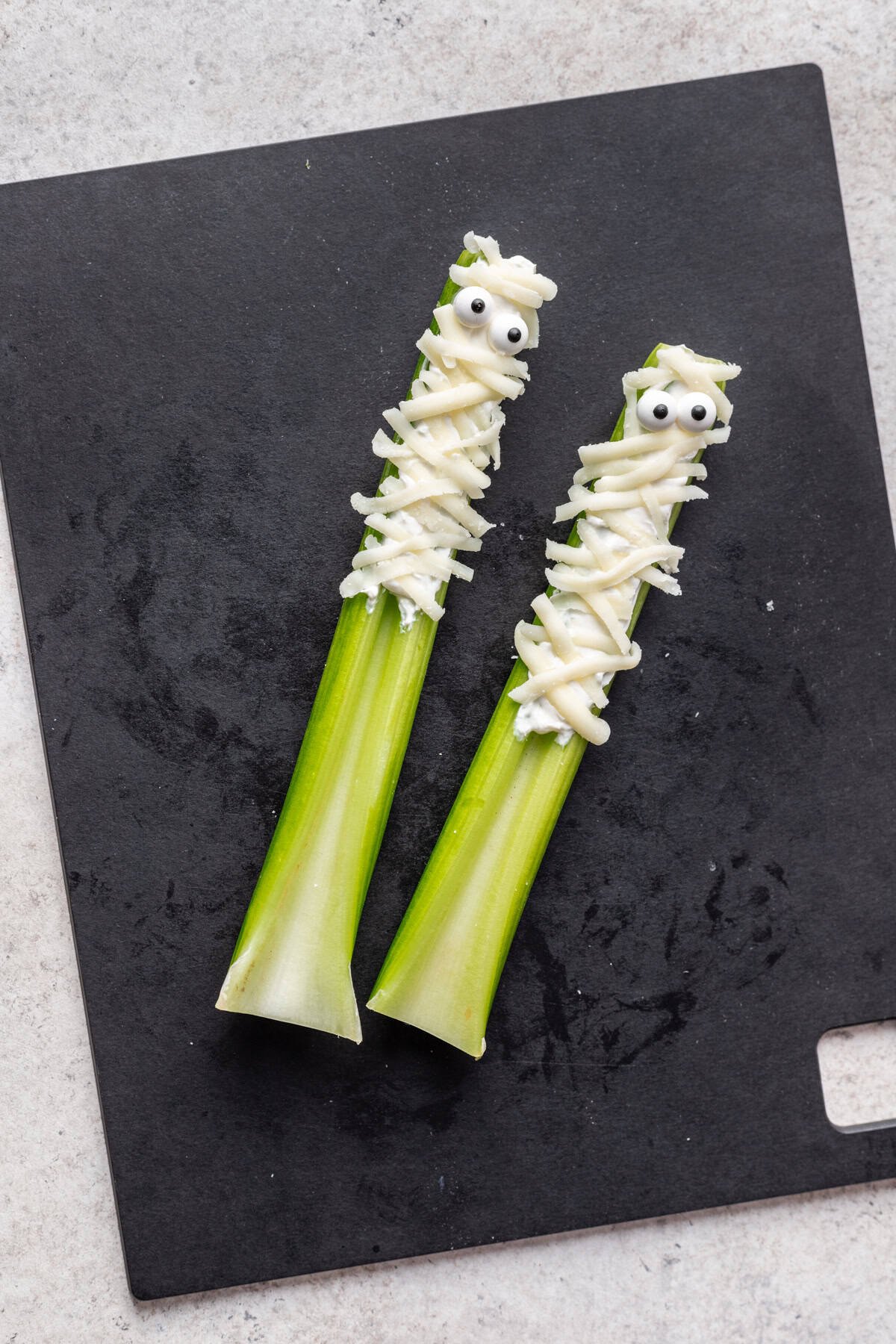 Celery "mummies" on a cutting board.