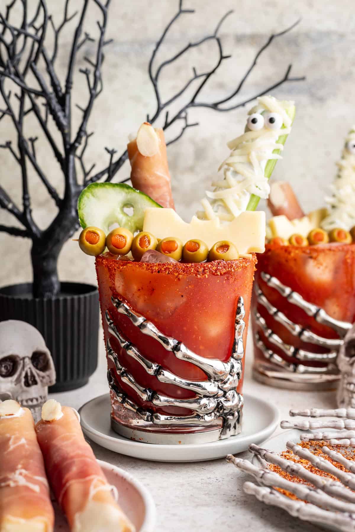 Halloween bloody mary in a skeleton hand decorated cup.