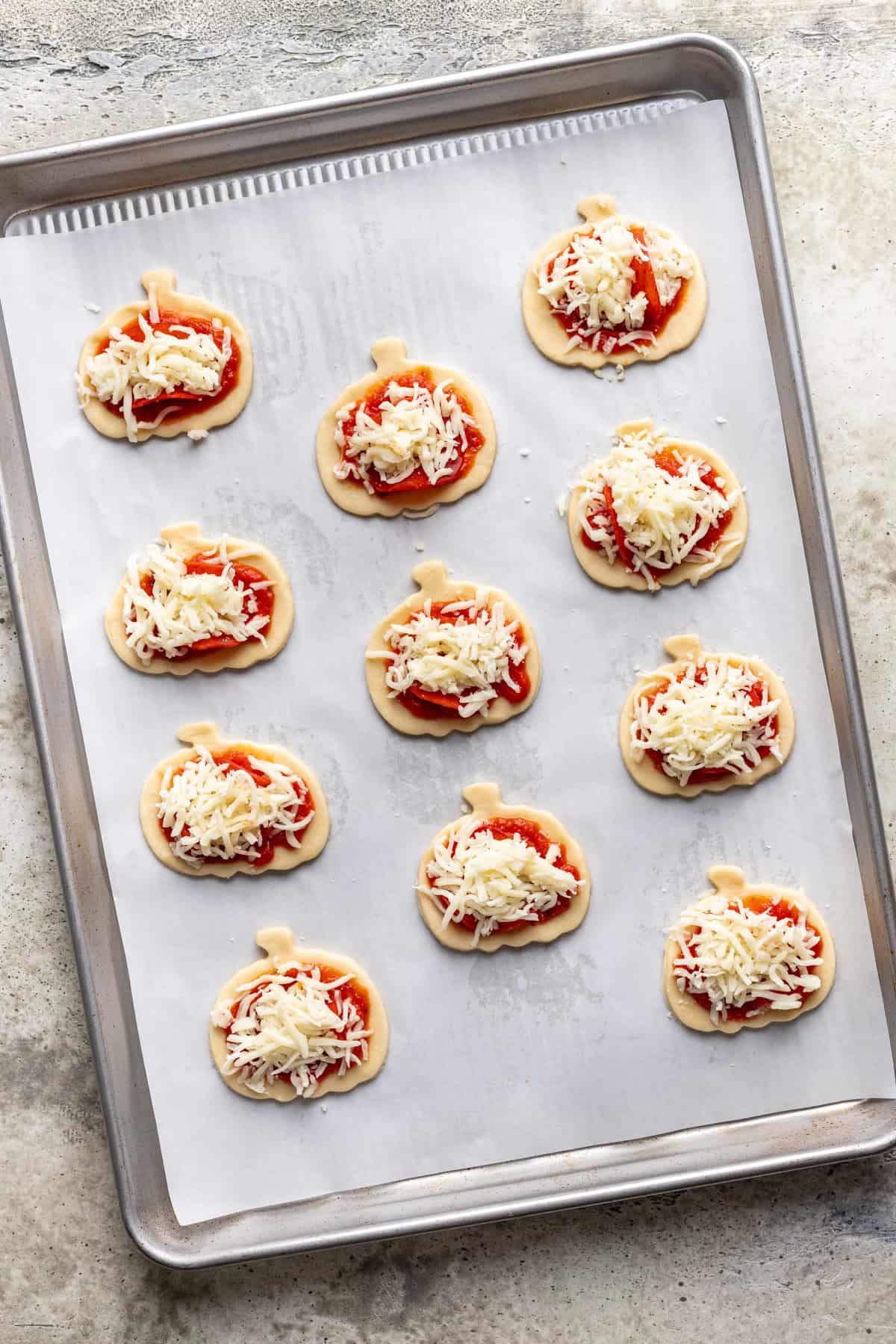 Pizza sauce, pepperoni, and mozzarella added to each pumpkin dough.