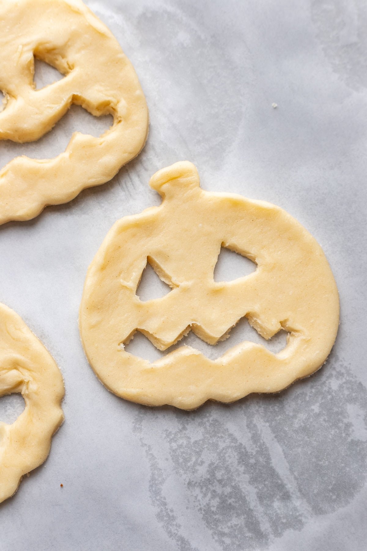 Jack o lantern face cut into the pumpkin shaped dough.