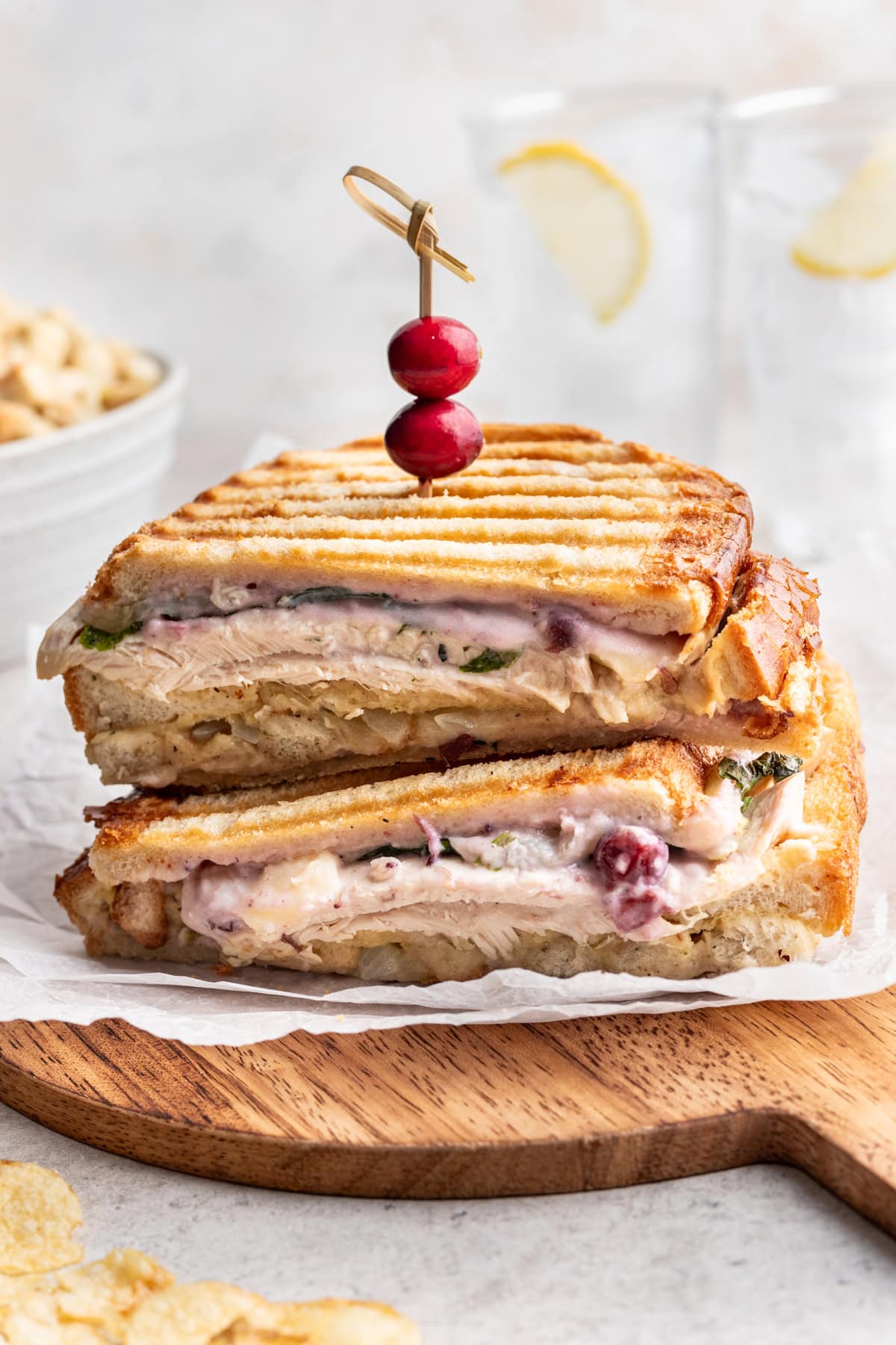 Thanksgiving leftovers piled into a warm panini sandwich on a cutting board.