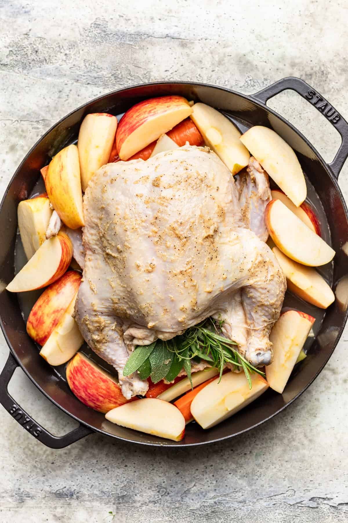 Fresh herbs, apples, and cider added to the pan with the chicken.