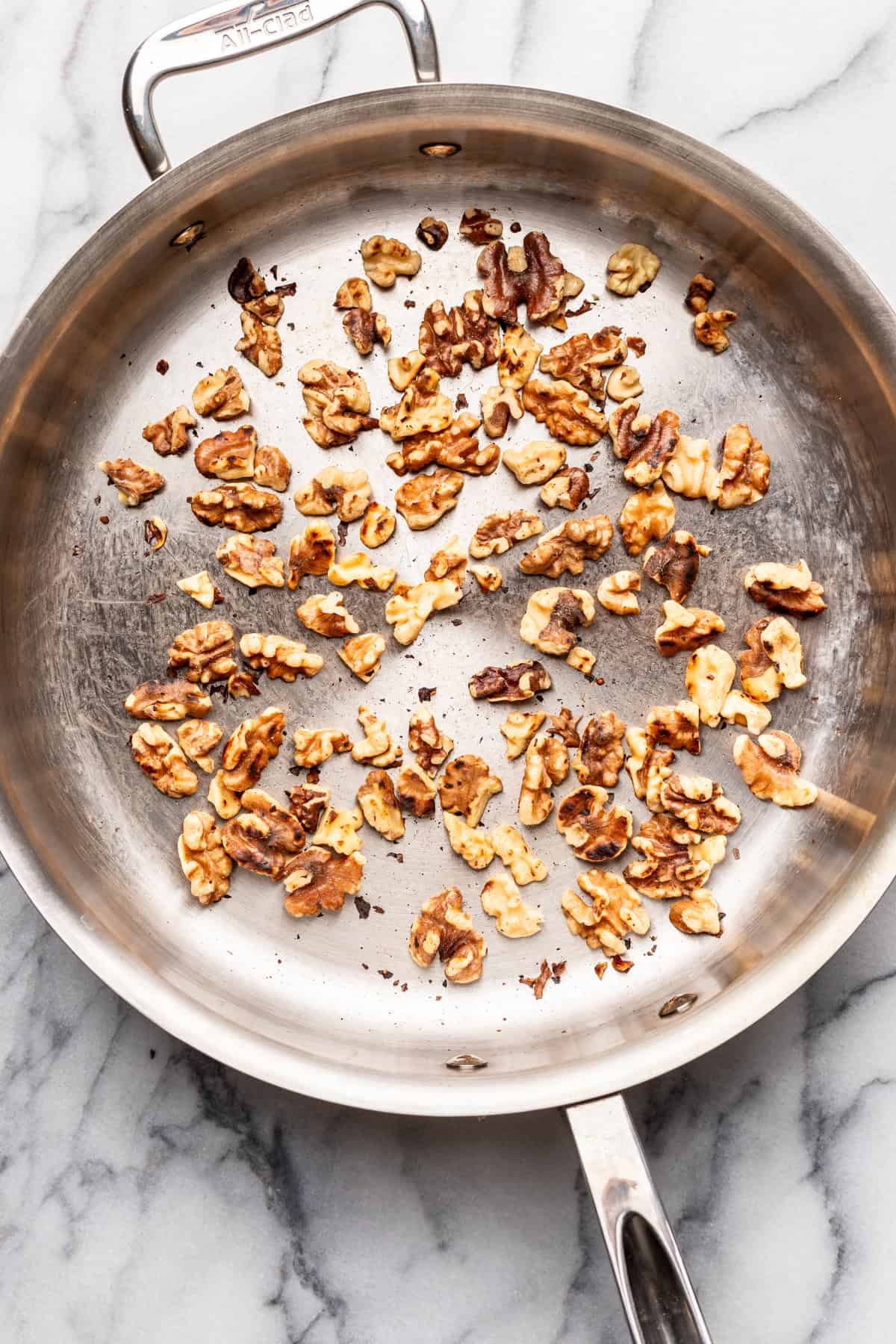 Walnuts toasting in a skillet.
