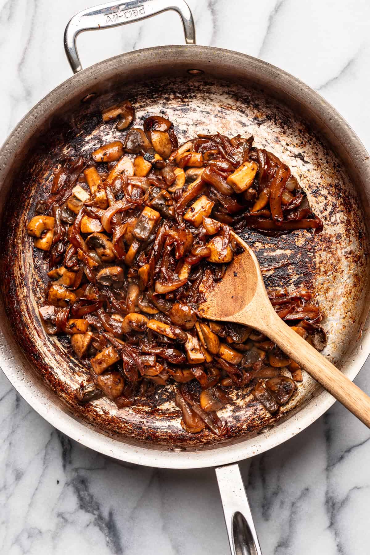 Mushrooms and onions cooked in a skillet.