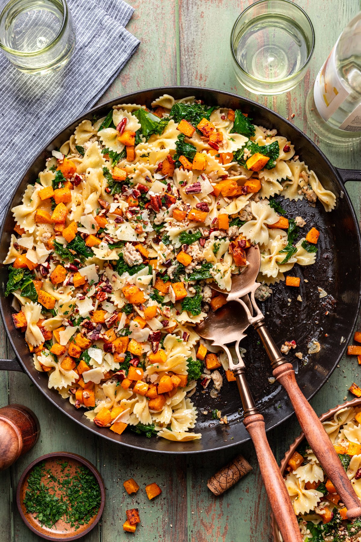 Roasted butternut squash pasta with ground chicken and kale in a large cast iron skillet.