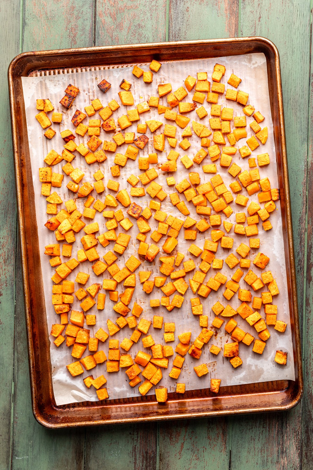 Roasted butternut squash on a large baking sheet.