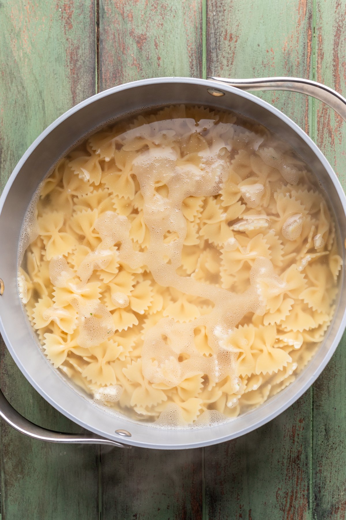 Bowtie pasta boiled in a pot.
