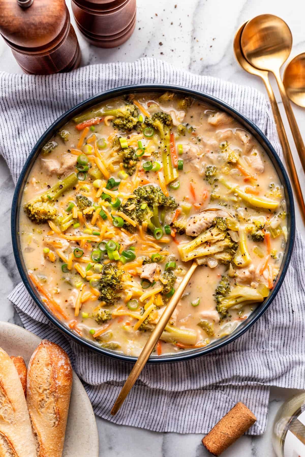 A bowl of Broccoli Cheddar Chicken Soup with a serving spoon.