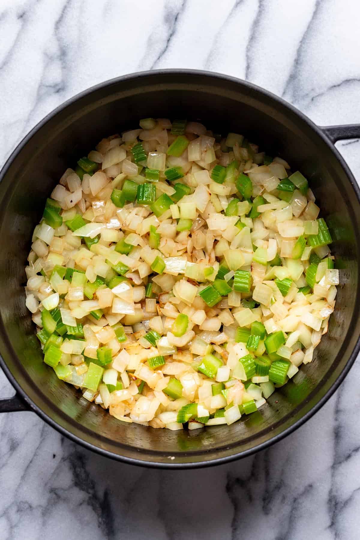 Onion and celery cooked in a large stock pot.