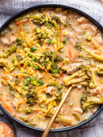 Broccoli cheddar chicken soup in a large bowl with a spoon.